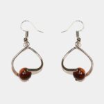 Boucles d'oreilles bicolore Falone en bois précieux, légères et élégantes, posées sur un fond clair.