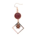 Boucles d'oreilles en bois d’amarante avec apprêts en métal doré rosé, posées sur une surface claire.
