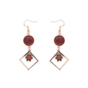 Gros plan sur une paire de boucles d'oreilles Kate, montrant les détails artisanaux et les textures du bois.