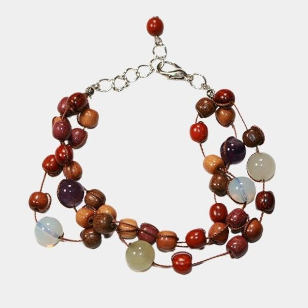 Zoom sur les perles de bois multicolores du bracelet Lounia, mettant en avant leur beauté unique et artisanale.