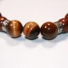Gros plan sur le fermoir artisanal du bracelet en bois, mettant en valeur son design unique et son savoir-faire exceptionnel.