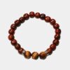 Bracelet Om Œil du Tigre Terence en bois et pierre naturelle sur fond gris.