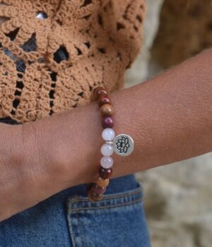 bracelet élastique composé de perles en bois multicolore et de pierres naturelles en Quartz rose, mis en valeur sur un fond blanc.