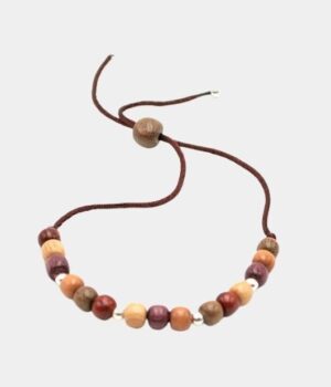 Bracelet Fatya en bois multicolore, un bijou artisanal unique qui allie élégance et naturel sur fond gris.