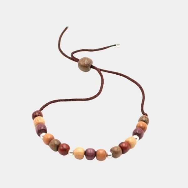 Bracelet Fatya en bois multicolore, un bijou artisanal unique qui allie élégance et naturel sur fond gris.