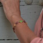 Un gros plan sur le bracelet Livia en Jaspe impérial vert, mettant en valeur les perles de bois multicolore.