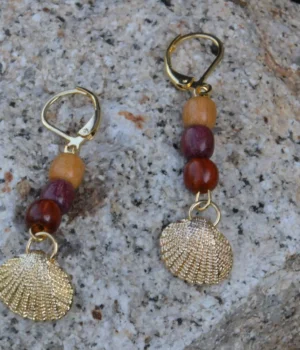 Boucles d'oreilles pendantes en bois avec filigrane doré et motif coquillage, design artisanal unique.