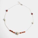 Collier en agate bleue turquoise porté par un mannequin, mettant en avant son design élégant.