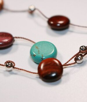 Gros plan sur les perles en turquoise du collier Myra