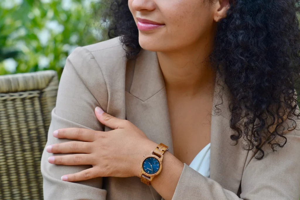 Une femme élégamment habillée portant la montre en bois de noyer Velvet, démontrant son esthétique chic et moderne.