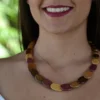 Collier artisanal Sylviane en bois multicolore avec une finition élégante en perles plates ovales.