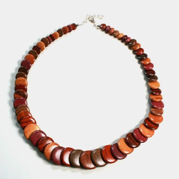 Collier artisanal en bois multicolore avec perles de différentes essences sur fond gris