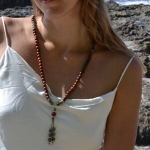 Modèle portant le collier mala acajou et labradorite Zoé autour du poignet comme un bracelet.
