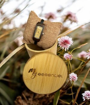 Coffret en ébène collection Carlita My Essenciel contenant une montre en bois femme posée sur son coussin en toile naturelle, avec maillons supplémentaires.