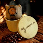 Coffret en noyer Explorer My Essenciel contenant une montre en bois homme posée sur son coussin en toile naturelle, avec maillons supplémentaires.