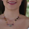 Collier artisanal en bois d'acajou et amarante avec cabochon de verre multicolore.