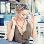 Collier sautoir multicolore artisanal en bois précieux avec perles plates ovales et finition élégante.