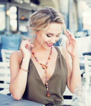 Collier sautoir multicolore artisanal en bois précieux avec perles plates ovales et finition élégante.