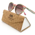 Lunettes en bois Spector multicolore posées sur une table en bois, mettant en valeur leur monture colorée faite à partir de skateboards recyclés.