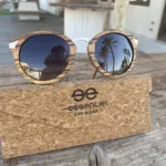Lunettes Elisabeth dans leur étui en liège naturel, entourées d'accessoires de mode minimalistes.