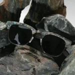 Vue rapprochée des détails de la monture Clubmaster en bois de noyer et nacre naturelle des lunettes Classic 211 AE.