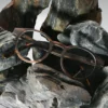 Lunettes Paul Optic 2 pour femmes avec monture en bois d’ébène et branches en acétate bio sur un fond marbre