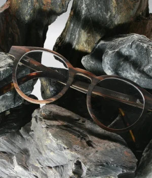 Lunettes Paul Optic 2 pour femmes avec monture en bois d’ébène et branches en acétate bio sur un fond marbre