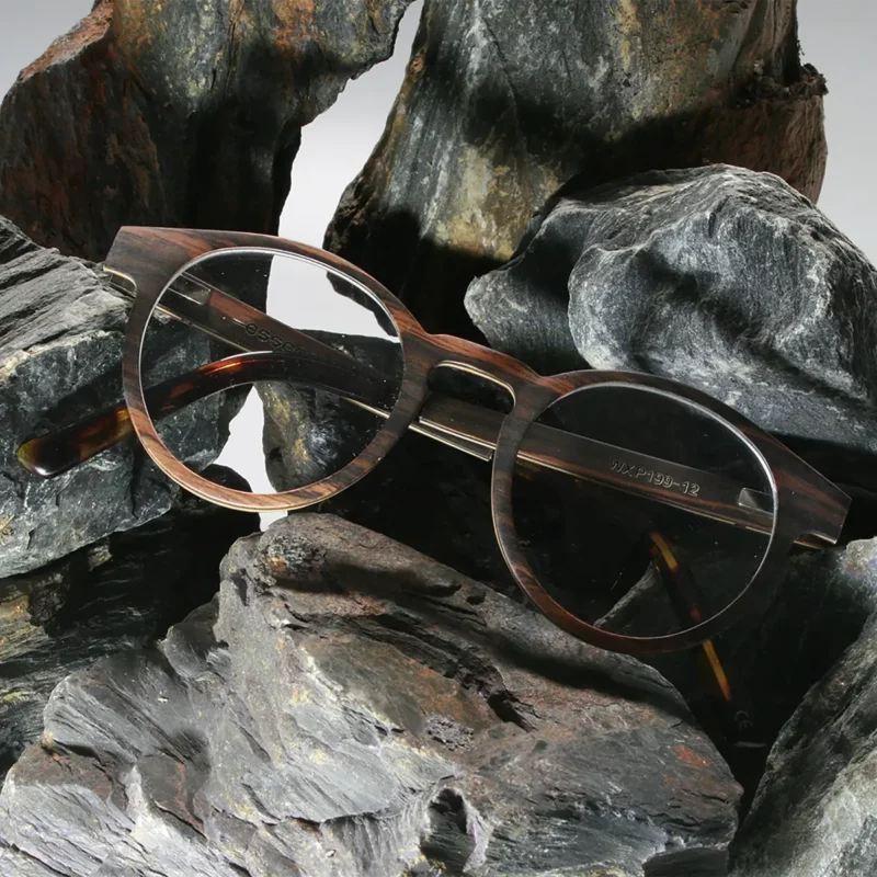 Lunettes Paul Optic 2 pour femmes avec monture en bois d’ébène et branches en acétate bio sur un fond marbre