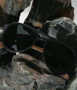 Lunettes solaires Mac-Arthur en bois d’ébène devant un fond minimaliste blanc