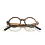 Lunettes optiques en bois OCEANIA pour femme posées sur une table, mettant en valeur leur design classique et éco-responsable.