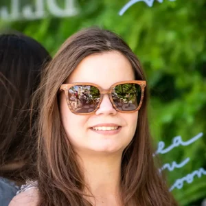 Modèle féminin portant les lunettes Grace avec une tenue estivale dans un décor lumineux.