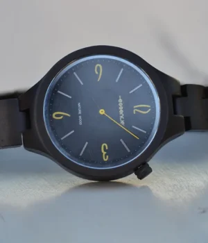 Montre en bois d'ébène Aretha sur fond blanc, mettant en évidence son design élégant et minimaliste.