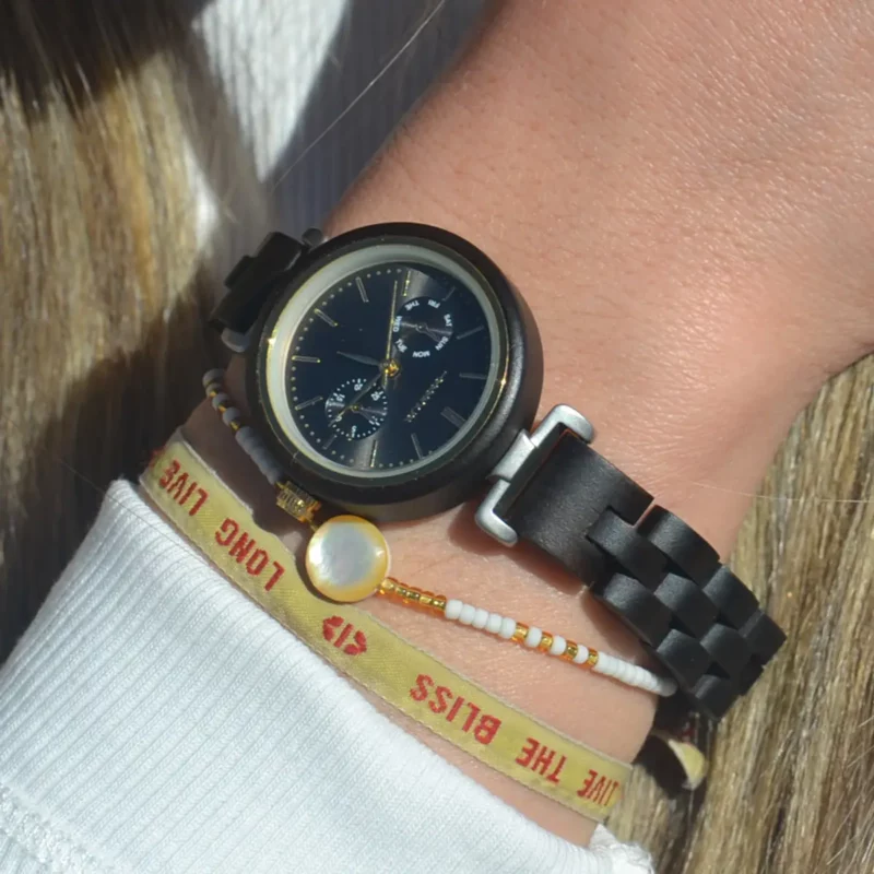 Montre pour femme en bois d'ébène modèle Maya, dotée d'un boîtier de 30 mm et d'un cadran doré, alliant élégance naturelle et design raffiné.