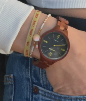 Cadran noir de la montre Aretha avec accents jaunes sur les chiffres 3, 6, 9 et 12.