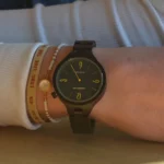 Cadran noir de la montre Aretha en bois d'ébène avec accents jaunes sur les chiffres.