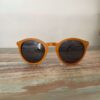 Lunettes de soleil Spector Orange en bois recyclé, design multicolore posé sur une élégante surface marbrée, mettant en valeur leur originalité et leur finition artisanale.