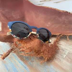 Détail des lunettes Clapton Bleu montrant la monture en bois multicolore et un design artisanat unique. Accessoire tendance et écologique.