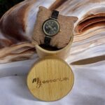 Coffret en bambou collection Maya My Essenciel contenant une montre en bois d'ébène femme posée sur son coussin en toile naturelle, avec maillons supplémentaires.
