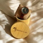 Coffret en bambou collection Charley My Essenciel contenant une montre en bois femme posée sur son coussin en toile naturelle, avec maillons supplémentaires.