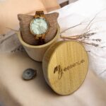 Coffret en bambou collection Vénissia My Essenciel contenant une montre en bois zébrano femme posée sur son coussin en toile naturelle, avec maillons supplémentaires.