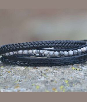 Bracelet multi-rangs Spacio en cuir noir et agate grise avec fermoir magnétique, posé sur une surface en pierre.