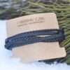 Bracelet multi-rangs pour homme affichant 4 cordons de cuir noir et des pierres de lave texturées.