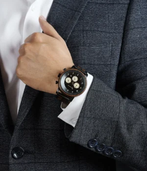 Gros plan sur le boîtier en bois de noyer massif de la montre pour homme Nomadis.