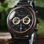 Cadran noir métallisé avec chiffres arabes et trois compteurs chronographes élégants.