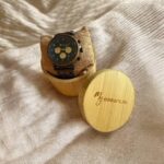 Coffret en noyer Nomadis bleue My Essenciel contenant une montre en bois chronographe posée sur son coussin en toile naturelle, avec maillons supplémentaires.