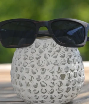 Lunettes en bois Cutis black posées sur une table en bois avec une lumière naturelle.