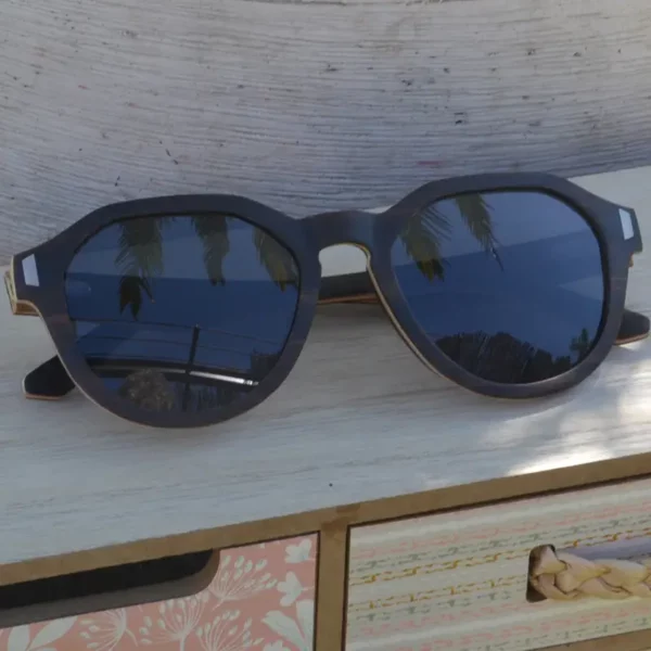 Lunettes solaires Charlie noir en bois ébène. Légères, artisanales et personnalisables avec étui en liège inclus. Design français remarquable, garanties 2 ans.