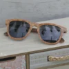 Zoom sur la monture Wayfarer des lunettes en bois avec détails des veines naturelles.