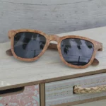 Zoom sur la monture Wayfarer des lunettes en bois avec détails des veines naturelles.
