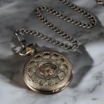 Vue rapprochée de la montre à gousset Tomy avec fond vert pâle et chiffres romains noirs.